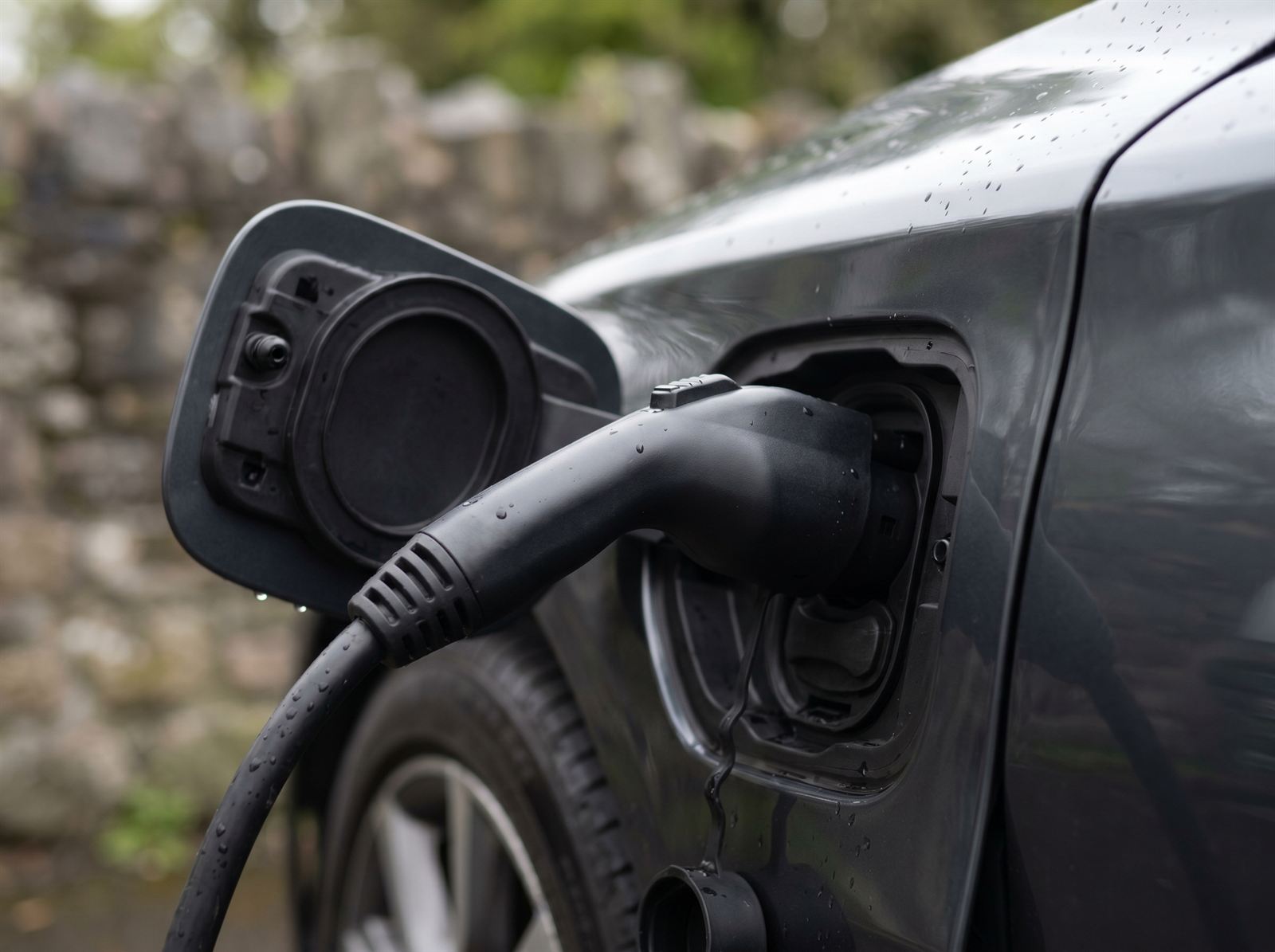 Close-up of an EV charging cable plugged into a car